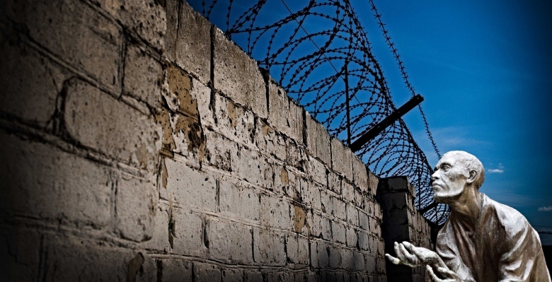 man at prison wall