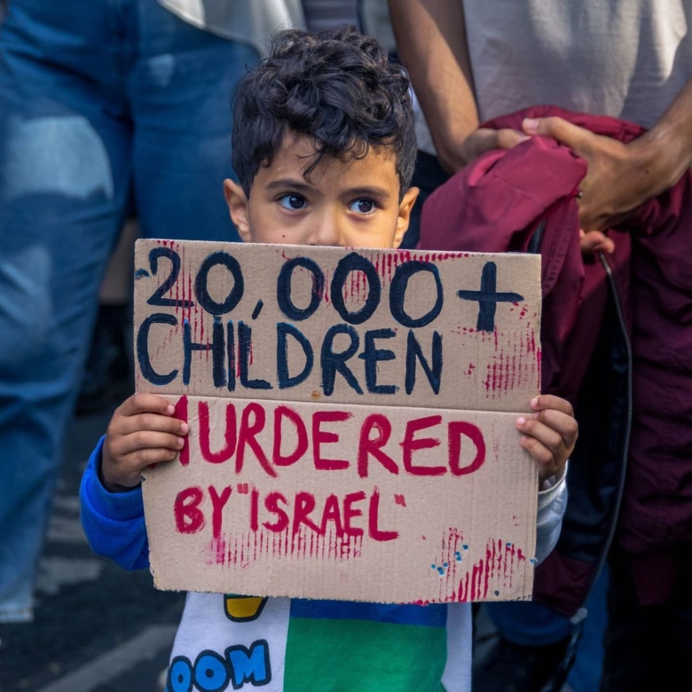 child holding sign about dead kids in Gaza