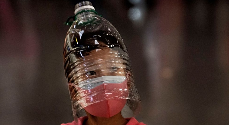 boy wearing water bottle as a face mask