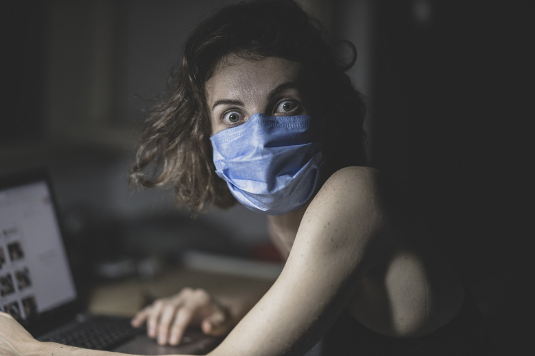 photo of scared woman wearing a face mask