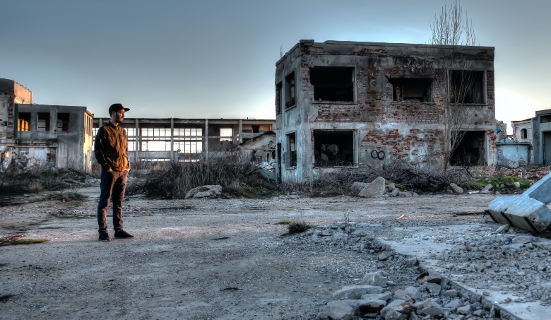 man looking at abandoned building