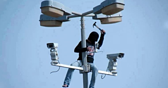 man destroying surveillance cameras